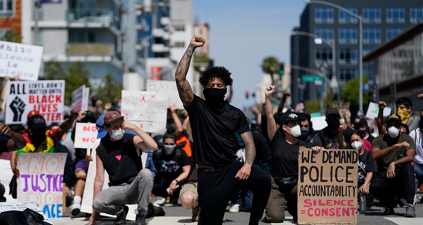 Demonstrators kneel outside the Long Beach Police Department in Long Beach, California during a protest on May 31, 2020. 