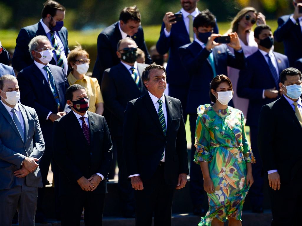 El presidente de Brasil, Jair Bolsonaro, asiste a una ceremonia en el Palacio Presidencial en Brasilia sin mascarilla, acompañado de ministros y otras autoridades, la mayoría de los cuales están usando mascarilla, el 7 de septiembre de 2020.
