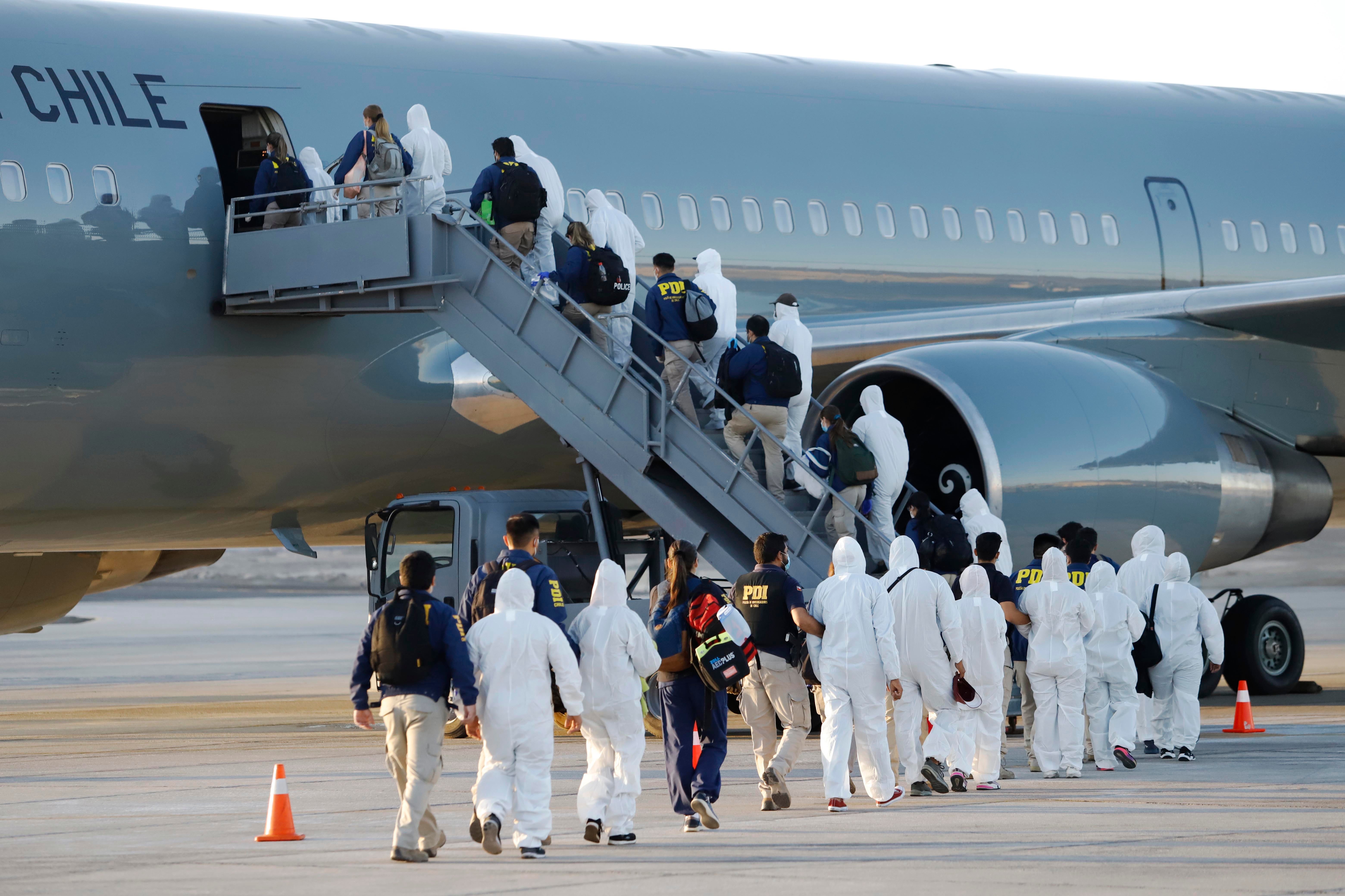 Migrantes venezolanos abordan un avión mientras son deportados de Chile, en el Aeropuerto Internacional General Diego Aracena Aguilar en Iquique, Chile, el 10 de febrero de 2021.
