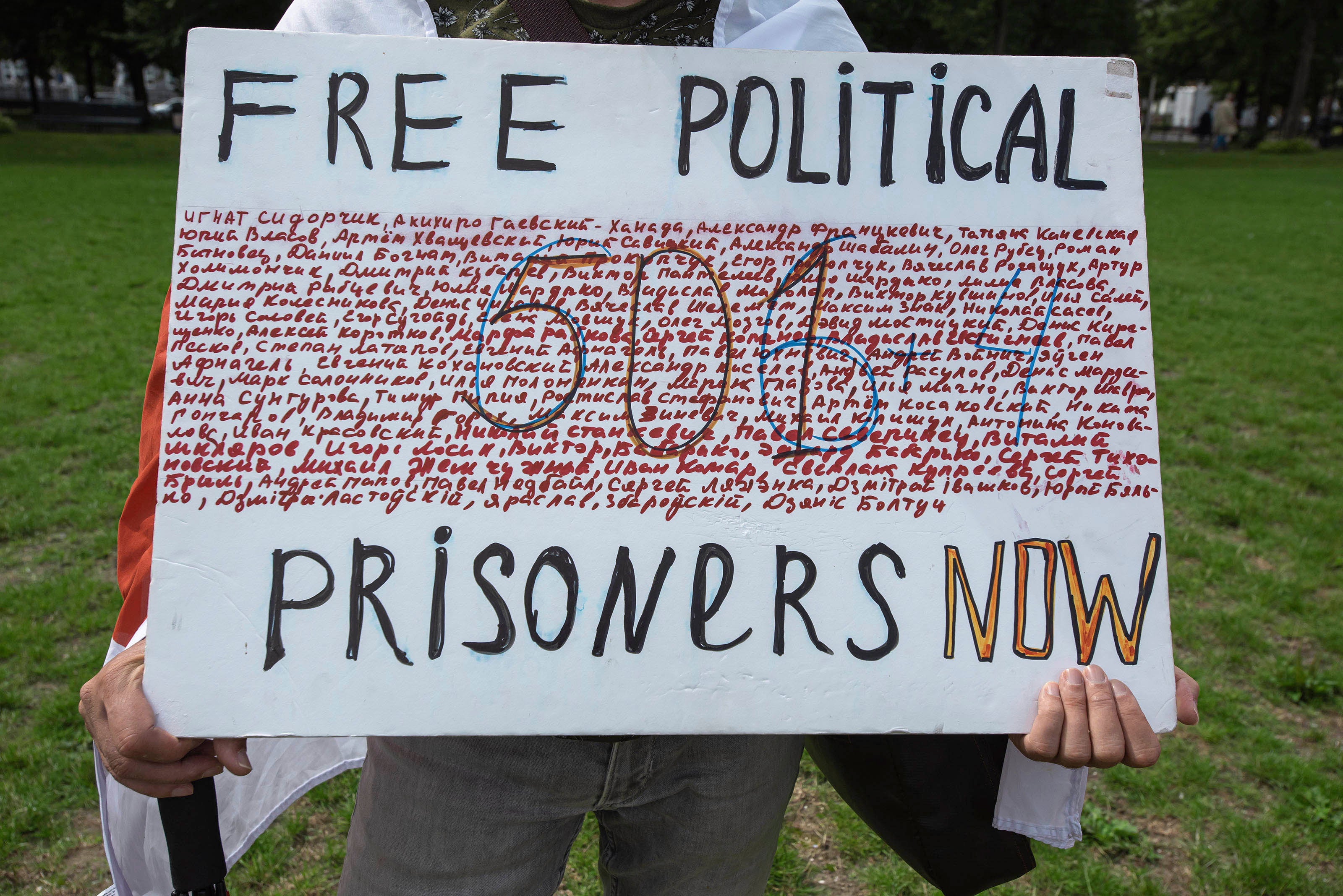 In The Hague, Netherlands, on August 7, a demonstrator holds a placard showing the names of some of those arbitrarily detained in Belarus for protesting against President Alexander Lukashenko, and calling for their release.