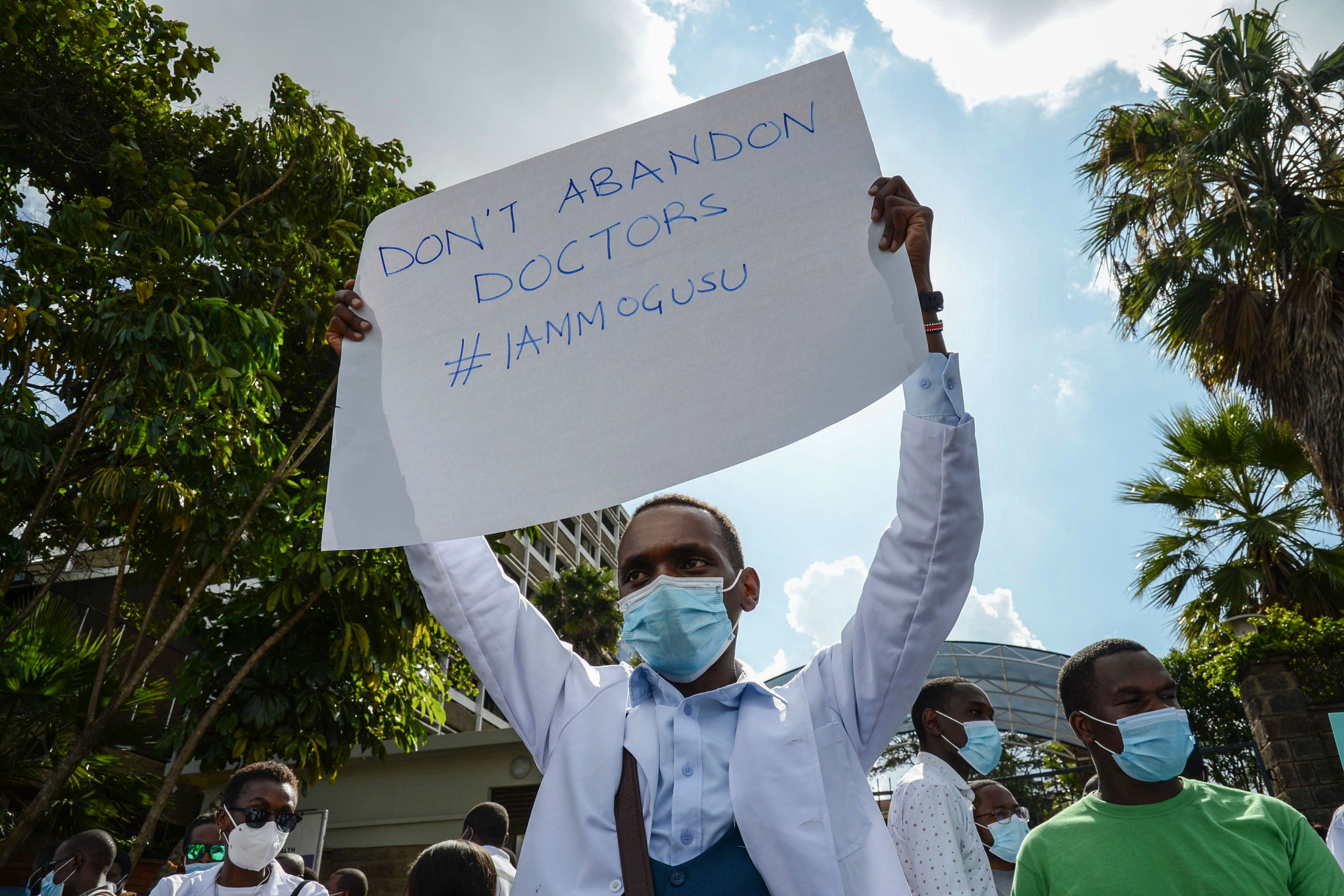 Healthcare workers protest outside the Ministry of Health headquarters in Nairobi, Kenya to honor one of their colleagues, Dr. Stephen Mogusu, a 28-year-old health worker who succumbed to Covid-19.