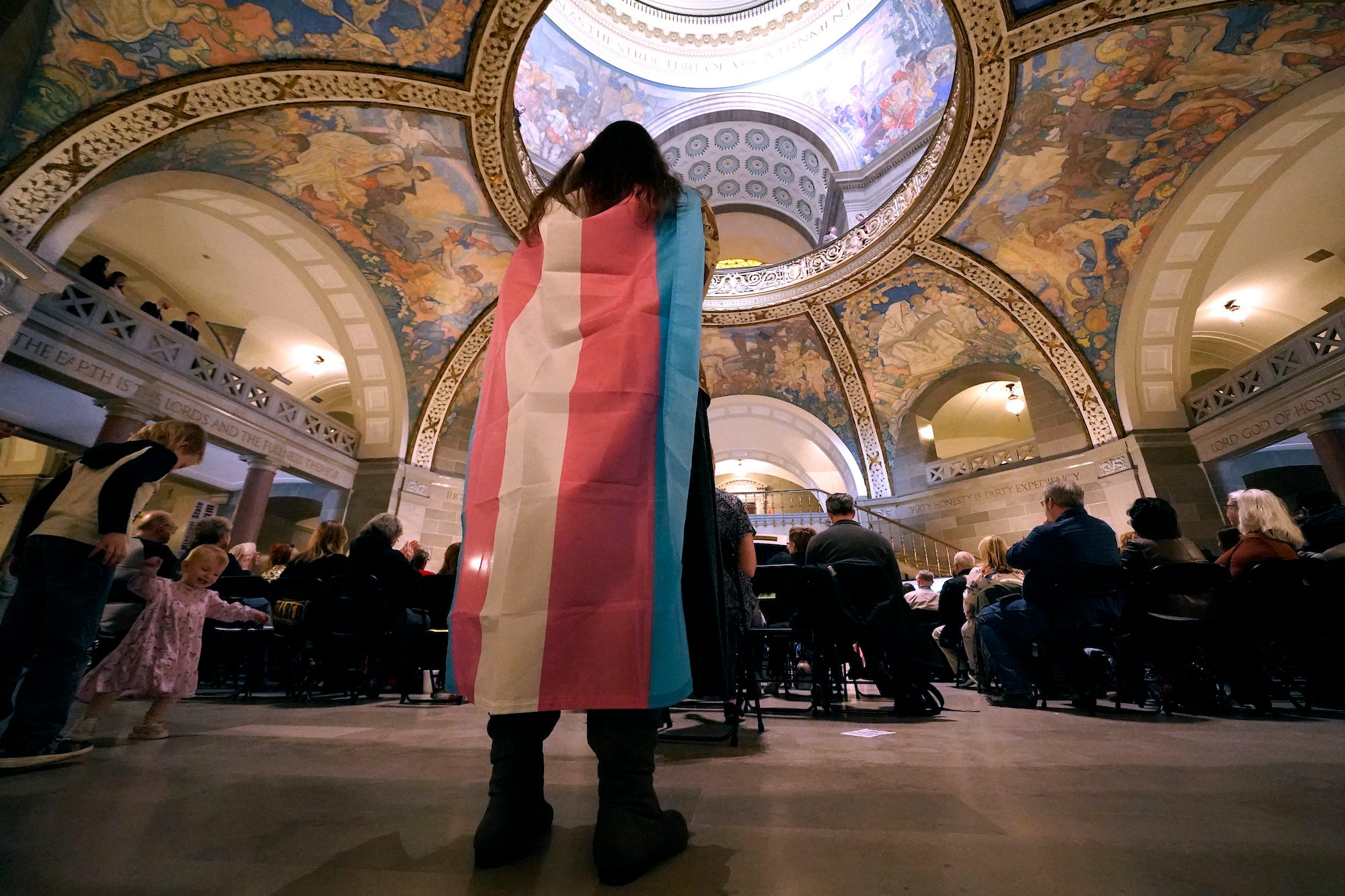 An activist wears a the transgender pride flag as a counter protest during a rally in favor of a ban on gender-affirming health care legislation at the Missouri Statehouse in Jefferson, US, March 20, 2023.
