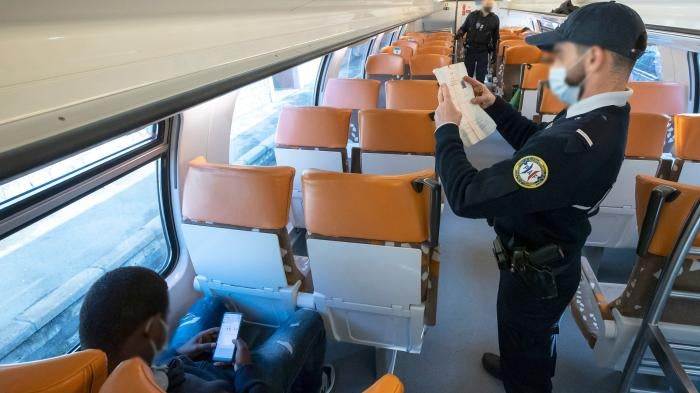 A member of the French border police checks identity documents in March 2021 at the Menton-Garavan station, the first French train station for those travelling between Genoa, in Italy, and Nice, in France.