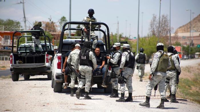 Mexican National Guard members arrest a migrant who tried crossing the Río Bravo in Ciudad Juárez,