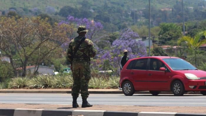 A soldier stands in the road in Manzini on October 20, 2021 where at least 80 people were injured in Eswatini.