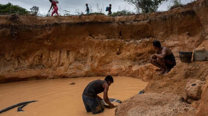 Men look for diamonds and gold in a recently dug mine