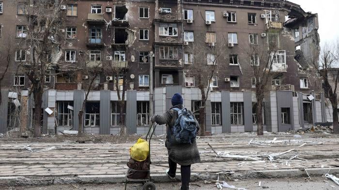 A resident looks at an apartment building damaged during heavy fighting near the Illich Iron & Steel Works Metallurgical Plant in Mariupol, Ukraine, April 16, 2022.