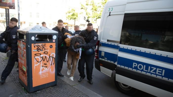 German police forcibly detain a man participating in a protest