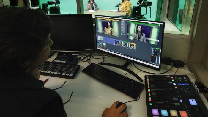 Women journalists being filmed in a tv news studio