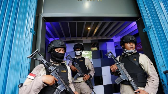 Police officers guard the entry of the T1 night club in Jakarta on October 9, 2017, after they raided it and arrested 10 people for alleged violations of the anti-pornography law. 