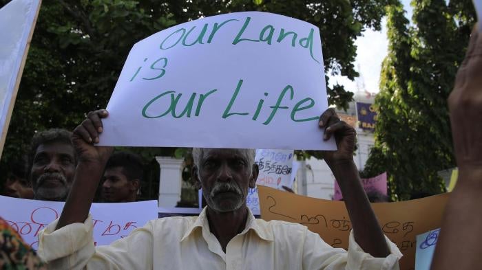  A Sri Lankan Tamil man holds a placard during a protest in Colombo on August 21, 2018, demanding the release of lands still occupied by the military. 