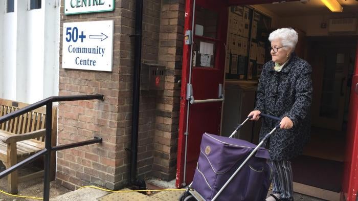 Older woman leaving a community center with programs for older people in East London. 