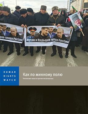 Мужчины на массовом про- властном митинге в Грозном держат плакат «Путин и Кадыров – опора России». Грозный, Чечня, январь 2016.