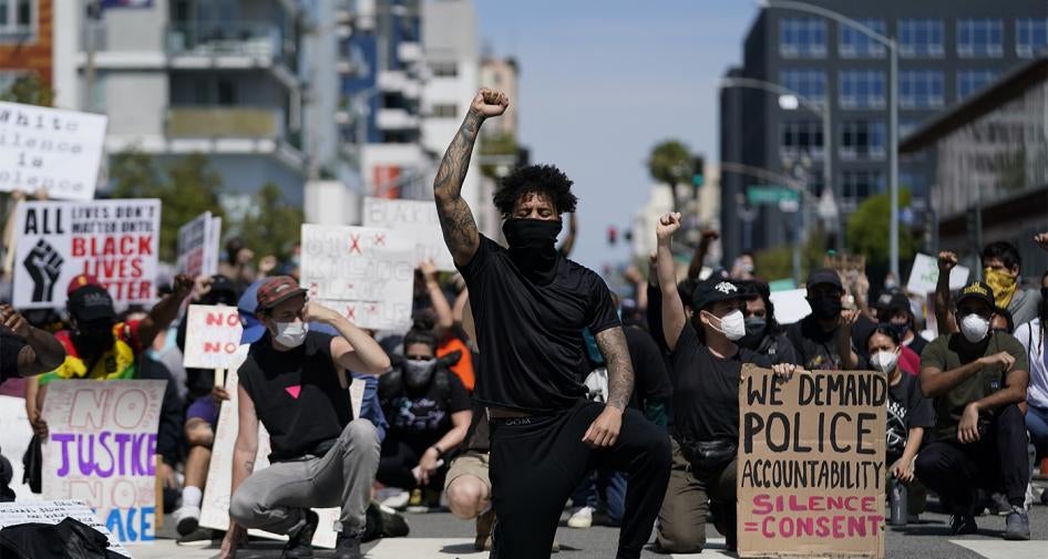 Demonstrators kneel outside the Long Beach Police Department in Long Beach, California during a protest on May 31, 2020. 
