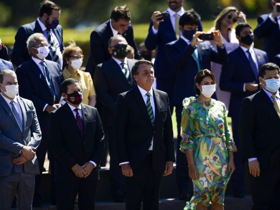 El presidente de Brasil, Jair Bolsonaro, asiste a una ceremonia en el Palacio Presidencial en Brasilia sin mascarilla, acompañado de ministros y otras autoridades, la mayoría de los cuales están usando mascarilla, el 7 de septiembre de 2020.