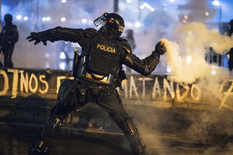 Un agente del ESMAD lanza un cartucho de gas lacrimógeno manualmente a manifestantes el 28 de mayo en Bogotá, Colombia.