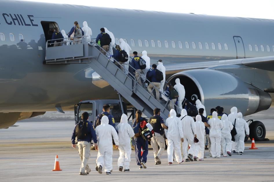 Venezuelan migrants board a plane as they are being deported from Chile, at the General Diego Aracena Aguilar International Airport in Iquique, Chile, on February 10, 2021. 