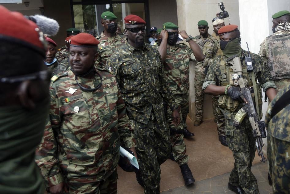 Le colonel guinéen Mamady Doumbouya (au centre) est protégé par des soldats lourdement armés après une réunion avec une délégation de la CEDEAO à Conakry, le 10 septembre 2021. 