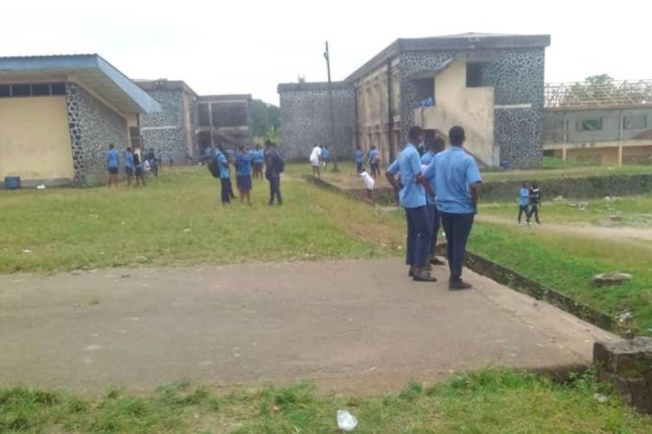 Children stand in a school courtyard