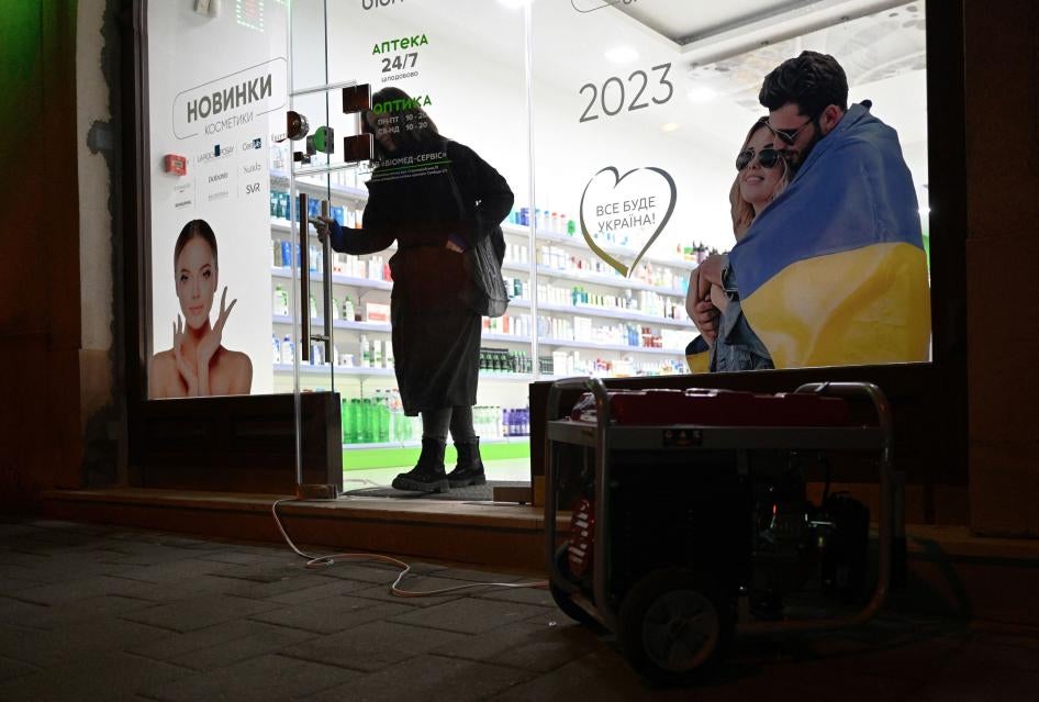 A customer walks out of a drugstore lit by a portable generator during a blackout in the Western Ukrainian city of Lviv following massive Russian airstrikes on January 14, 2023. 