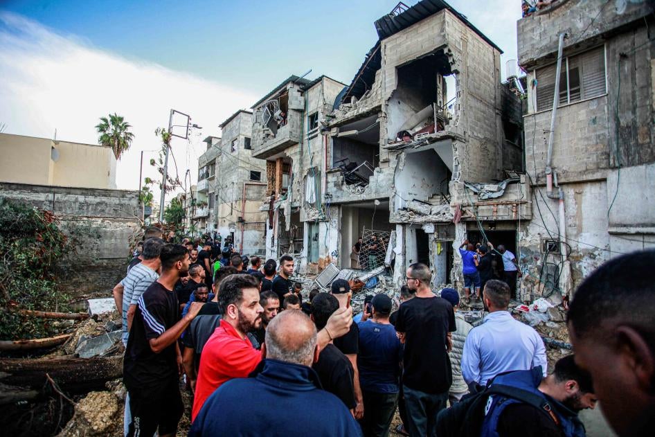 es hommes palestiniens étaient rassemblés devant un bâtiment endommagé par une frappe aérienne menée par l’armée israélienne à Tulkarem, en Cisjordanie, le 14 novembre 2023, lors d’une opération contre des membres présumés d’un groupe armé.
