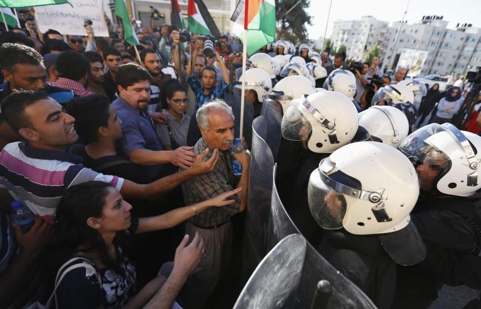 La policía antidisturbios palestina se enfrenta a un grupo de manifestantes que protestan por la coordinación de seguridad entre la Autoridad Palestina (AP) e Israel, en la ciudad de Ramallah en Cisjordania el 23 de junio de 2014