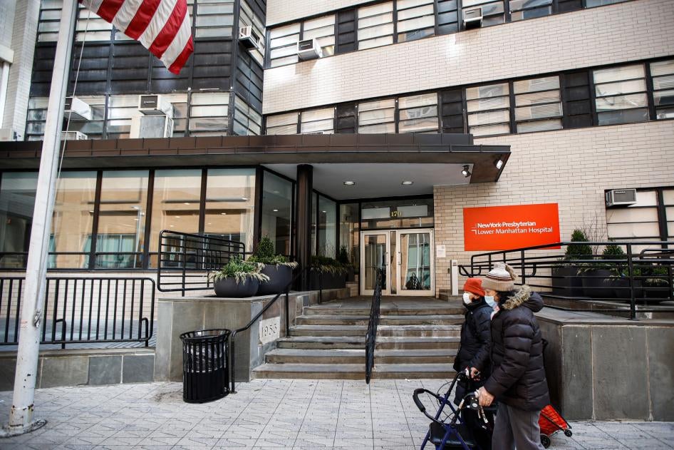 Pedestrians wearing masks walk by New York Presbyterian Lower Manhattan Hospital in New York, Monday, March 16, 2020.