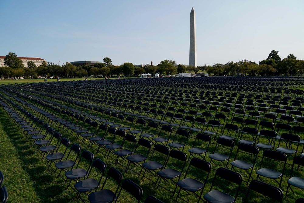 Rows of empty black chairs laid out in front of the Washington Monument