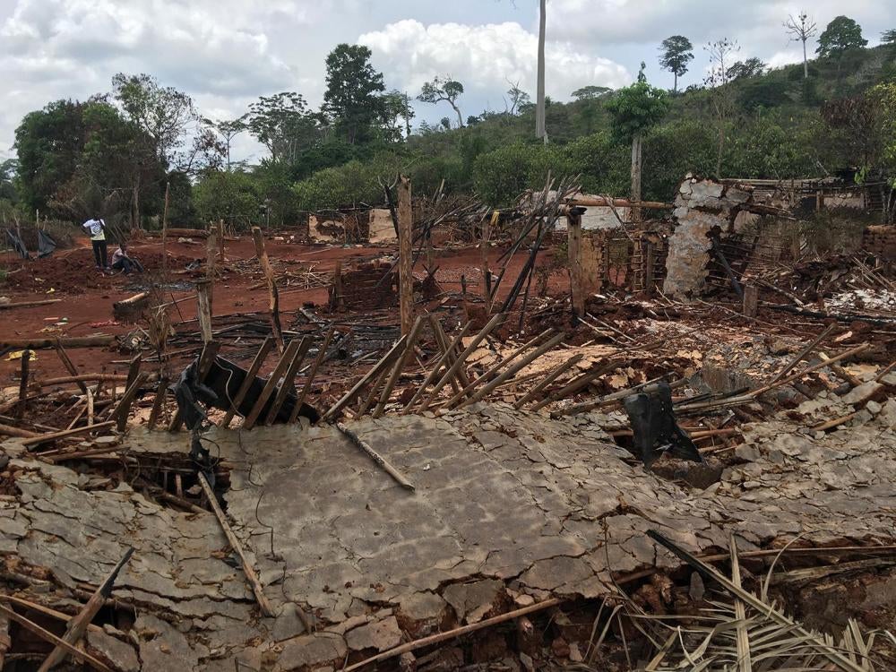 Farmers stand among houses destroyed during an eviction operation in the protected forest of Goin-Débé, Côte d'Ivoire
