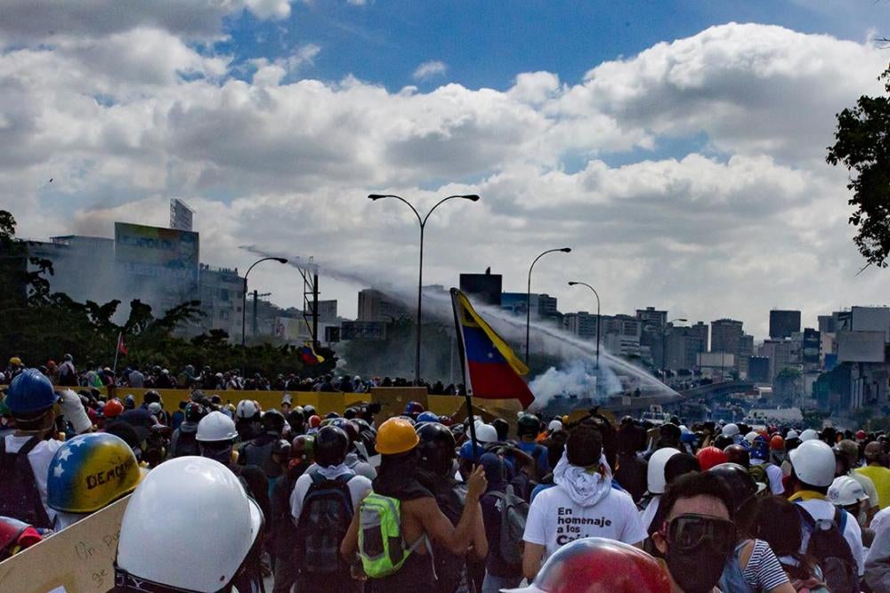 Miembros de las fuerzas de seguridad venezolanas usan un cañón de agua para dispersar una manifestación contra el gobierno en la autopista Francisco Fajardo, Caracas, 18 de mayo de 2017.