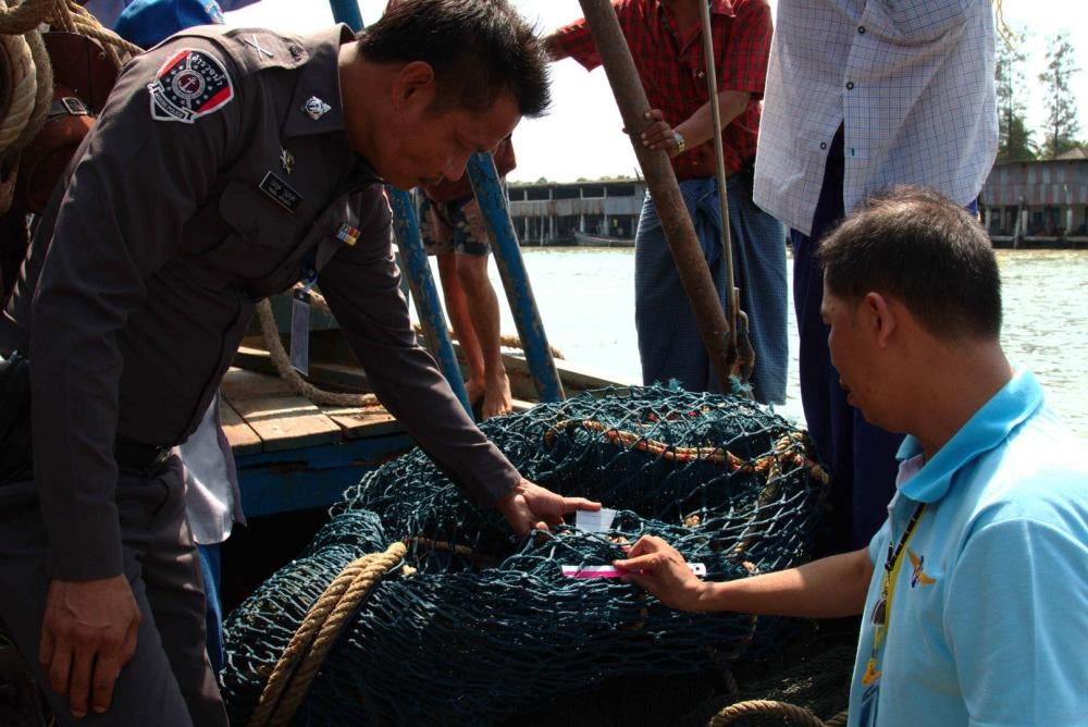 Marine Police and Department of Fisheries officers measure the mesh size on a trawl net during a PIPO inspection in Ranong, March 13, 2016. Thai reforms have primarily focused on addressing overfishing and illegal fishing. 
