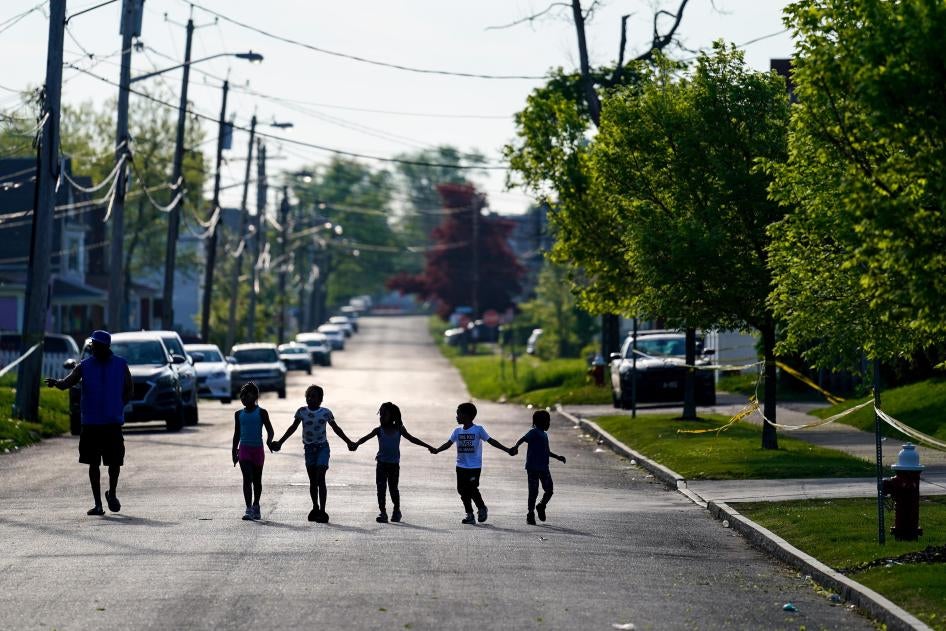 Children walk hand in hand down a street