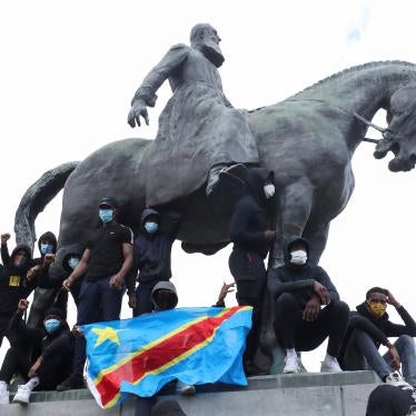 Demonstrators stand on the statue of Leopold II as one of them holds a national flag of the Democratic Republic of Congo during a protest for the end of racial injustice in Brussels, Belgium, June 7, 2020.