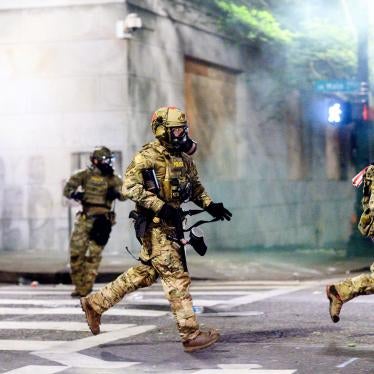 Federal officers run after dispersing protesters in Portland, Oregon, July 22, 2020.