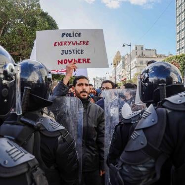 A protester holds up a sign saying “Police Everywhere, Justice Nowhere” during nation-wide protests calling for social justice and government reform on January 23, 2021, Avenue Habib Bourguiba, Tunis, Tunisia.