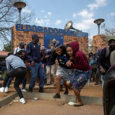 Protesters run for cover as they clash with police at Eldorado Park police station in Johannesburg, South Africa, August 27, 2020. 