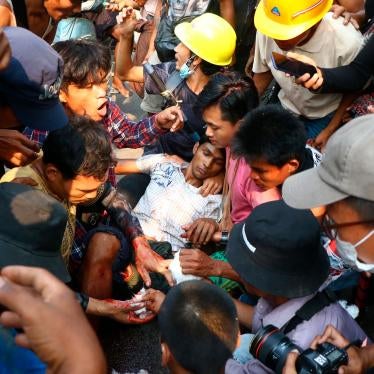 Protesters surround an injured man in Hlaing Tharyar township in Yangon, Myanmar, March 14, 2021.