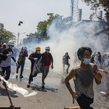 Anti-coup protesters run from teargas deployed by the police during a demonstration in Yangon, Myanmar, March 1, 2021.