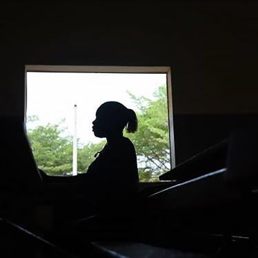 A young woman stands by a window at a secondary school in Dakar. 