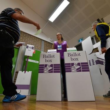 A voter drops his ballot paper into the ballot box during Australia's general election in Sydney.