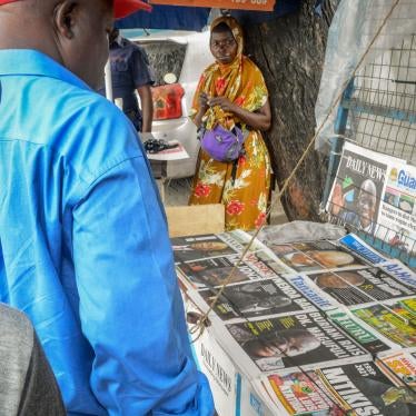 People stop to read front pages at a newspaper stand on a street in Dar es Salaam, Tanzania, March 18, 2021.