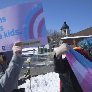 A protester holds a sign that reads "Trans kids are kids"