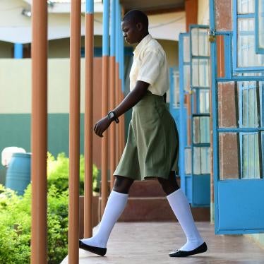 A female student wearing a school uniform walks out of a building