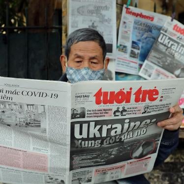 A man reads a Vietnamese newspaper featuring frontpage coverage of the Russian invasion of Ukraine at a stall in Hanoi on February 25, 2022.