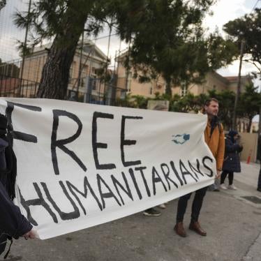 People hold a banner that reads "Free Humanitarians"
