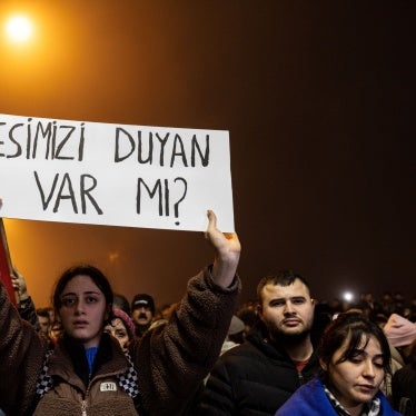 A commemoration held in Hatay, Turkey on the first anniversary of the February 6, 2023 earthquakes. Survivors of the earthquake and families of victims are campaigning for all those responsible for defective buildings to be held accountable. The banner here reads “Is anyone hearing us?” 