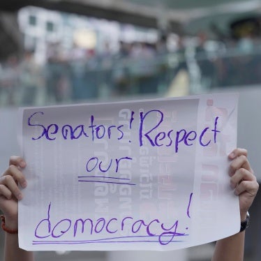 A protest sign that reads "Senators! Respect our democracy!"