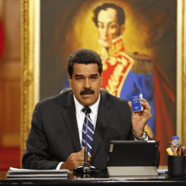 Venezuela's President Nicolas Maduro holds a copy of the country's constitution as he speaks during a news conference at Miraflores Palace in Caracas December 30, 2014.