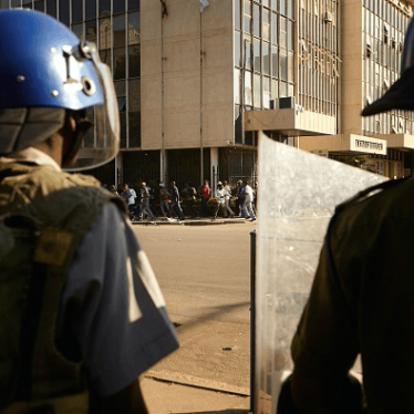 Zimbabween soldiers stand guard as citizens run through the Harare's streets, on August 1, 2018. 