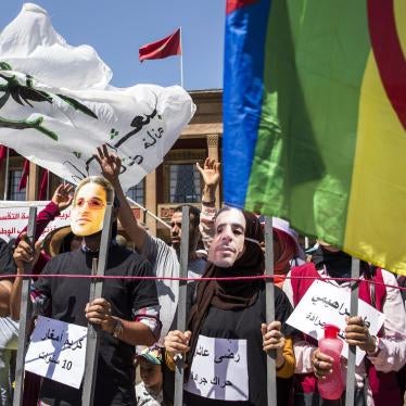 Rabat, Morocco, July 15, 2018: demonstrators protest heavy jail sentences on imprisoned activists by wearing masks showing their faces. © 2018 Fadel Senna/AFP/Getty Images